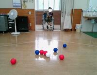 青いボールを投げようとしている児童